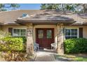 Inviting double-door entry with brick accents, elegant lighting, and seating for guests at 4701 Pine Harrier Dr, Sarasota, FL 34231