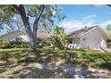 Beautiful single-story home with a well-manicured lawn and mature trees, showcasing a peaceful suburban setting at 4965 Marsh Field Rd, Sarasota, FL 34235
