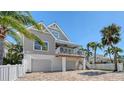 Beautiful two-story home featuring a quaint balcony, an exterior staircase, and a brick paver driveway at 5007 2Nd Ave, Holmes Beach, FL 34217
