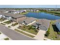 An aerial view of a neighborhood with a lake, showing houses with well-maintained lawns and landscaping at 5744 Woodland Sage Dr, Sarasota, FL 34238