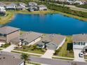 An aerial view shows homes backing onto a peaceful lake, showcasing the neighborhood layout at 5744 Woodland Sage Dr, Sarasota, FL 34238