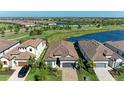 Scenic aerial view of a home with a tile roof and a paver driveway in a community with ponds and a golf course at 5817 Brandon Run, Bradenton, FL 34211