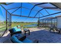Screened lanai with comfortable seating overlooking a serene pond view, ideal for outdoor relaxation at 5817 Brandon Run, Bradenton, FL 34211