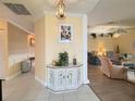 Bright entryway with decorative cabinet and view into open floor plan, living room, and dining room at 5906 Garden Lakes Majestic, Bradenton, FL 34203