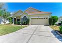 Well-maintained home with lush front lawn, manicured bushes, and a wide driveway leading to the garage at 6415 Fetterbush Ln, Lakewood Ranch, FL 34202