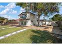 Backyard with a deck, fire pit, and two-story home with balcony at 6814 68Th E Ave, Bradenton, FL 34203