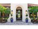 Elegant home entrance featuring manicured landscaping, blue decorative urns and a tiled walkway at 7211 Prestbury Cir, Lakewood Ranch, FL 34202
