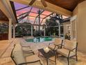 Relaxing patio with comfortable seating area overlooking a screened-in pool and lake at 7921 Waterton Ln, Lakewood Ranch, FL 34202