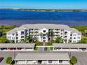 Scenic aerial view of a waterfront condominium complex with covered parking and lush landscaping near the water at 1020 Tidewater Shores Loop # 107, Bradenton, FL 34208