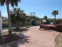 Tranquil waterfront backyard featuring a patio, lush palm trees, and a private boat dock for easy access to the water at 1027 Newton St, Englewood, FL 34224