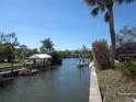 Picturesque waterfront view showcasing a serene canal lined with lush greenery and private boat docks under a clear blue sky at 1027 Newton St, Englewood, FL 34224