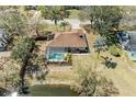 Aerial view of home with screened-in pool, pond, fenced backyard, and mature trees at 1127 133Rd E St, Bradenton, FL 34212