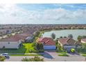 Stunning aerial view of a lakefront home with tile roof, lush landscaping, and community surroundings at 13145 Amerigo Ln, Venice, FL 34293