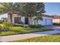 Attractive home with a three-car garage, red tile roof, well-maintained landscaping, and a brick driveway at 13145 Amerigo Ln, Venice, FL 34293
