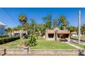 Unique stone house with an orange tile roof accent, set on a green lawn, with palm trees nearby at 1406 5Th W St, Palmetto, FL 34221