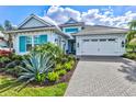 Beautiful home features turquoise shutters, neutral stucco, complementing the lush, mature landscaping at 15430 Blackmoor Ter, Lakewood Ranch, FL 34202