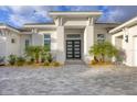 Close up of the front entrance with statement double doors and manicured landscaping at 16419 Kendleshire Ter, Lakewood Ranch, FL 34202