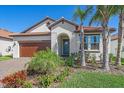 Well-maintained single-story home featuring tropical landscaping, tile roof, and paver driveway at 17216 Star Banks St, Wimauma, FL 33598