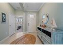 Bright foyer with tiled floor, coastal decor, and view to the bedroom at 17216 Star Banks St, Wimauma, FL 33598