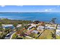 Aerial view of waterfront property outlined in red showing proximity to the bay and other homes at 1815 Palma Sola Blvd, Bradenton, FL 34209