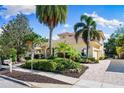 A lush front exterior with a paved driveway, palm trees, and manicured landscaping at 1904 Hyde Park St, Sarasota, FL 34239
