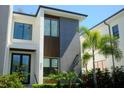 An exterior view showcasing the home's architecture, large windows, and meticulously maintained landscaping at 212 S Renellie Dr, Tampa, FL 33609