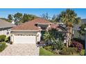 Charming single-story home boasts a well-manicured lawn, brick driveway and lush tropical landscaping at 3750 Summerwind Cir, Bradenton, FL 34209