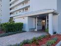 The building entrance features a brick path, lush landscaping, and an elevator for resident convenience at 3790 Pinebrook Cir # 103, Bradenton, FL 34209