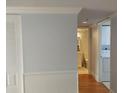 Hallway view with wainscoting, leading to bathroom with a laundry, adding convenience to the space at 3790 Pinebrook Cir # 103, Bradenton, FL 34209