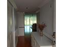 Inviting hallway with wood floors leads to a sunroom with sliding glass doors and lots of natural light at 3790 Pinebrook Cir # 103, Bradenton, FL 34209