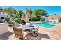 Outdoor patio area featuring comfortable seating, an umbrella-covered table, and views of the refreshing pool at 400 Nokomis S Ave, Venice, FL 34285