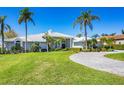 Striking home with well-manicured lawn and mature palm trees offering great curb appeal at 4002 Las Palmas Way, Sarasota, FL 34238