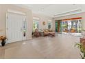 Bright living room featuring tile flooring, large windows, and sliding doors that open to a screened lanai at 4015 Bridlecrest Ln, Bradenton, FL 34209