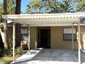 Front view of the single-story home entrance with a carport and well maintained yard at 4933 Village Gardens Dr # 211, Sarasota, FL 34234