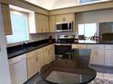 Updated kitchen with granite countertops, stainless steel appliances, and light wood cabinetry at 4933 Village Gardens Dr # 211, Sarasota, FL 34234