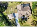 Aerial view of the home with a screened-in pool and detached garage at 4942 Hidden Oaks Ln, Sarasota, FL 34232