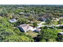 Aerial view of home showcasing mature landscaping and a screened-in pool at 4942 Hidden Oaks Ln, Sarasota, FL 34232