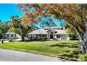 Charming single-story home with well-manicured lawn and mature trees at 4942 Hidden Oaks Ln, Sarasota, FL 34232