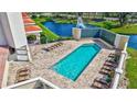 Relaxing outdoor pool area with lounge chairs, brick pavers, and lovely landscaping near the lake at 501 Haben Blvd # 202, Palmetto, FL 34221