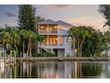 Waterfront home with multiple balconies, private dock and lush tropical landscaping at 504 59Th St, Holmes Beach, FL 34217