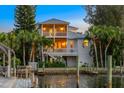 Waterfront home with multiple balconies, private dock and lush tropical landscaping at 504 59Th St, Holmes Beach, FL 34217