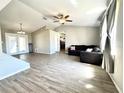 Spacious living room with wood-look flooring, ceiling fan, and sliding glass doors to the outside at 5104 Silver Bell Dr, Port Charlotte, FL 33948