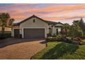 Beautiful one-story home with a brick driveway, three-car garage, and meticulously maintained landscaping at 5203 Rushmere Ct, Palmetto, FL 34221