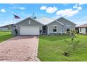 Charming single Gathering home with a two-car garage, appealing shutters and mature landscaping at 566 Corrientes Cir, Punta Gorda, FL 33983