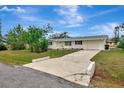 Single-story home featuring a long driveway, attached garage, and a lush front yard at 610 Cumberland Rd, Venice, FL 34293