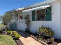 Charming single-story home with brick walkway, vibrant plants, and a welcoming entrance at 6125 Coral Way, Bradenton, FL 34207