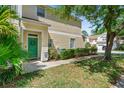 Inviting two-story condo with a well-manicured lawn and a welcoming green front door at 6320 Rosefinch Ct # 101, Lakewood Ranch, FL 34202