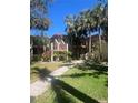 Beautiful exterior of two-story condos surrounded by palm trees and a well-maintained lawn and walkway at 6450 Wild Oak Bay Blvd # 240, Bradenton, FL 34210