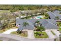 Aerial view of well-maintained single-story home and manicured lawn, pool, shrubs, and a two-car garage at 6907 Stoneywalk Ct, Bradenton, FL 34203