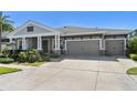 Single-story home showcasing a driveway leading to a three-car garage at 6913 Neopolitan Ct, Apollo Beach, FL 33572
